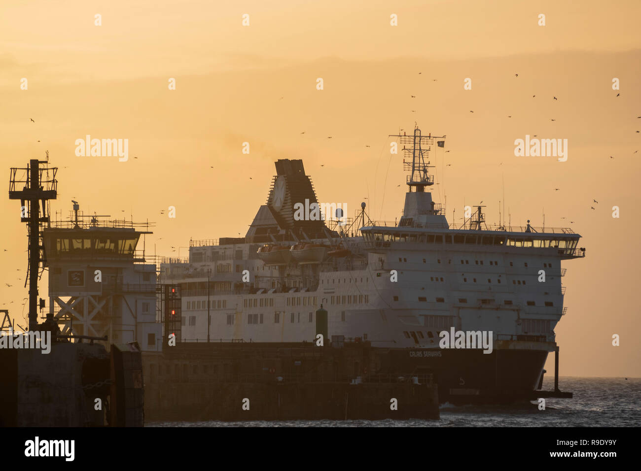 Fähren fahren in und aus dem geschäftigen Hafen - die Weihnachten weg ist in vollem Gange, als die Sonne über Dover steigt und die Fähren Überfahrt nach Calais. Stockfoto