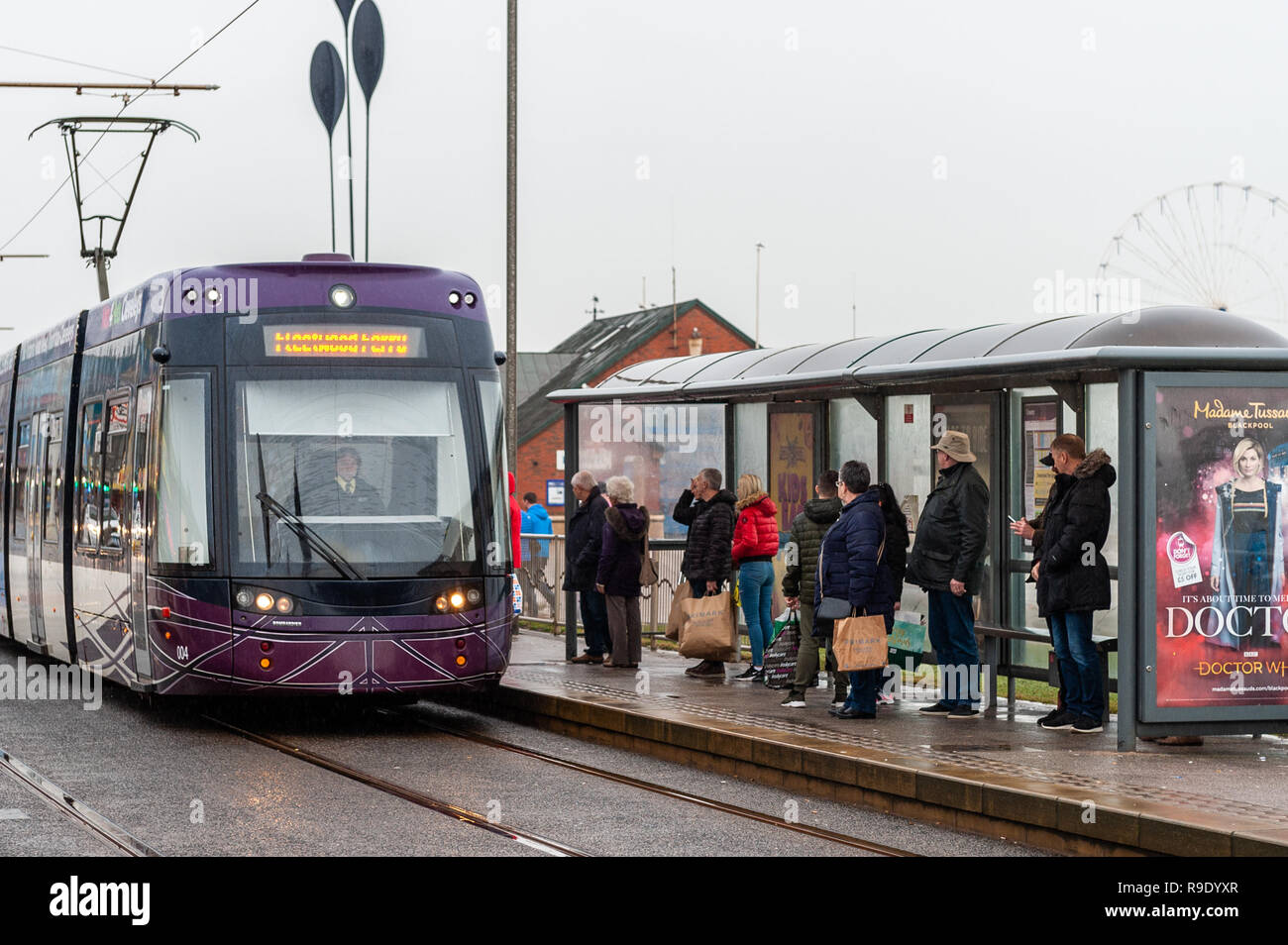 Blackpool, Großbritannien. 23. Dezember 2018. Trotz des regnerischen Wetters wartete eine Schlange von Leuten, um an der Küste von Blackpool in eine Straßenbahn zu steigen. Die Temperaturen werden über Nacht auf nur 1 °C sinken, aber morgen wird es trocken und hell sein mit sonnigen Wellen und Höchsttemperaturen von 8 °C. Kredit: AG News/Alamy Live News. Stockfoto