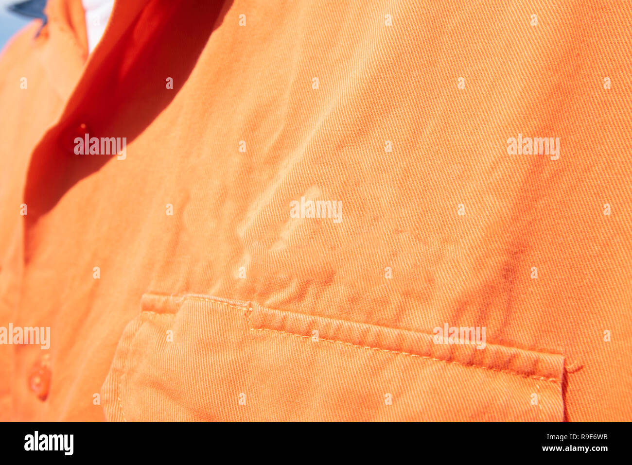 In der Nähe der linken Schulter vor Brust Tasche auf einer hohen Sichtbarkeit (Hi Vis) orange Arbeit Shirt ohne Beschriftung Stockfoto