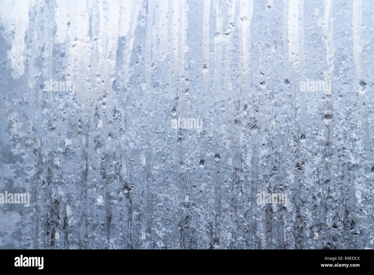 Die Gefrorenen Tropfen auf die gemusterte frostigen Winter Fenster Stockfoto