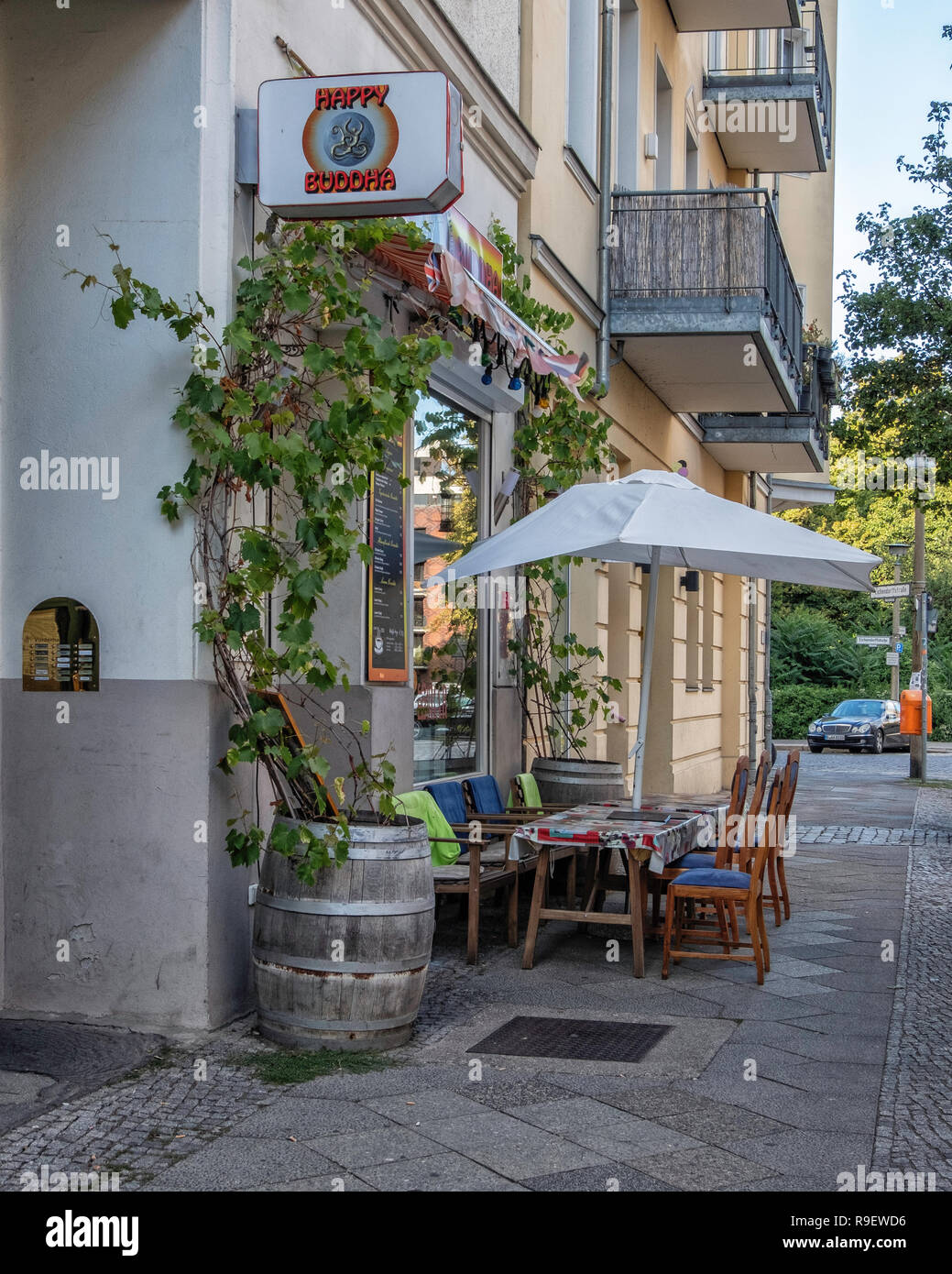 Berlin-Mitte. Happy Buddha indische Restaurant mit Tischen im Freien & zusätzliche Plätze auf einem geparkten Lkw Stockfoto