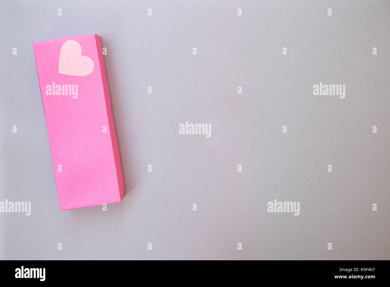 Big Pink Geschenkverpackung mit ein Herz der Liebe auf der Silbergrau Metall Hintergrund geöffnet. Label Handarbeit mit Liebe auf Herz Stockfoto