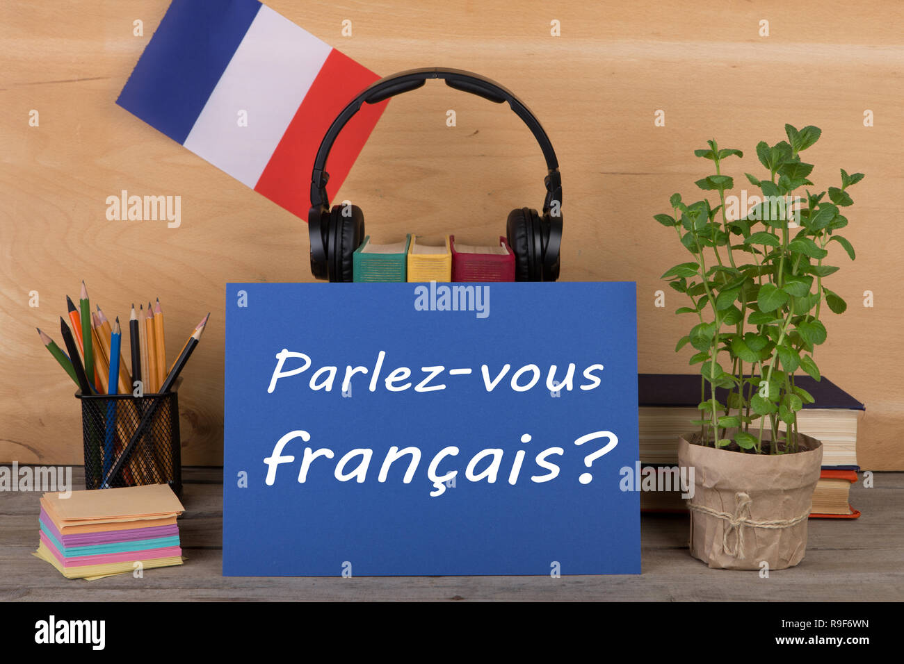 Konzept des Lernens der französischen Sprache - Papier mit Text "Parlez-vous Français?' (Parlez vous Francais?), Flagge der Frankreich, Bücher, Kopfhörer, Bleistifte Stockfoto