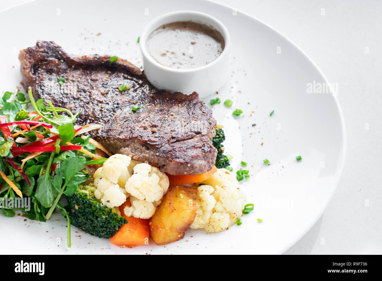 Premium Rindfleisch Steak mit gedünstetem Gemüse und Pilzsauce Gourmet-menü auf weiße Platte Stockfoto