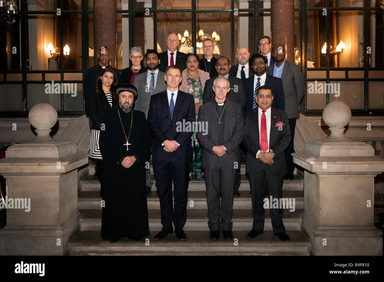 Auf 0001 Montag, 24. Dezember Außenminister Jeremy Hunt (vordere Reihe 2. links), der Erzbischof von Canterbury Justin Welby (vordere Reihe zweiter von rechts) und Herr Ahmad (rechts) beigetreten sind, werden durch andere christliche Führer, darunter Erzbischof Angaelos der koptisch-orthodoxen Kirche in Großbritannien (links), und Würdenträgern und Politikern mit Überlebenden der Verfolgung der Christen bei einem Treffen im Auswärtigen Amt in London mit einem Embargo belegt. Stockfoto