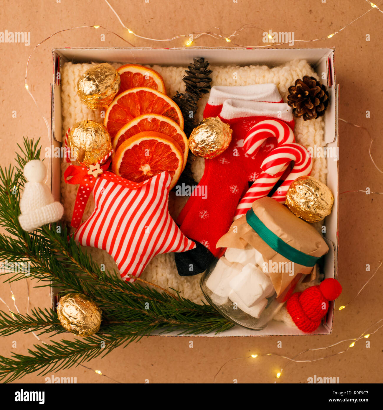 Eine persönliche Box mit Geschenke für Weihnachten und das neue Jahr, eine Reihe von süßen Sachen, traditionelle Spezialitäten und Dekor, eine einfache Idee für ein schönes Geschenk für Familie Stockfotografie