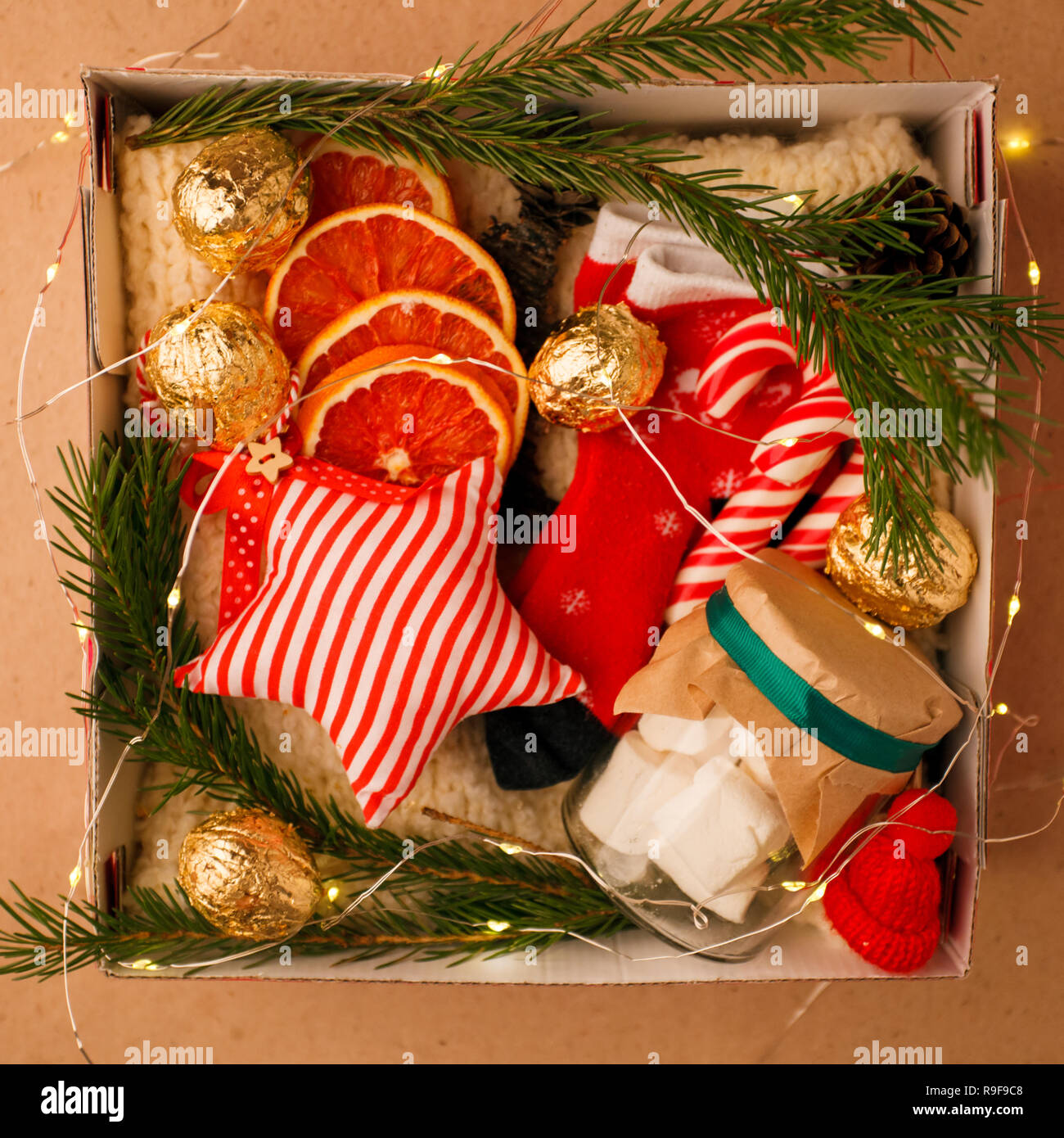 Eine persönliche Box mit Geschenke für Weihnachten und das neue Jahr, eine Reihe von süßen Sachen, traditionelle Spezialitäten und Dekor, eine einfache Idee für ein schönes Geschenk für Familie Stockfotografie