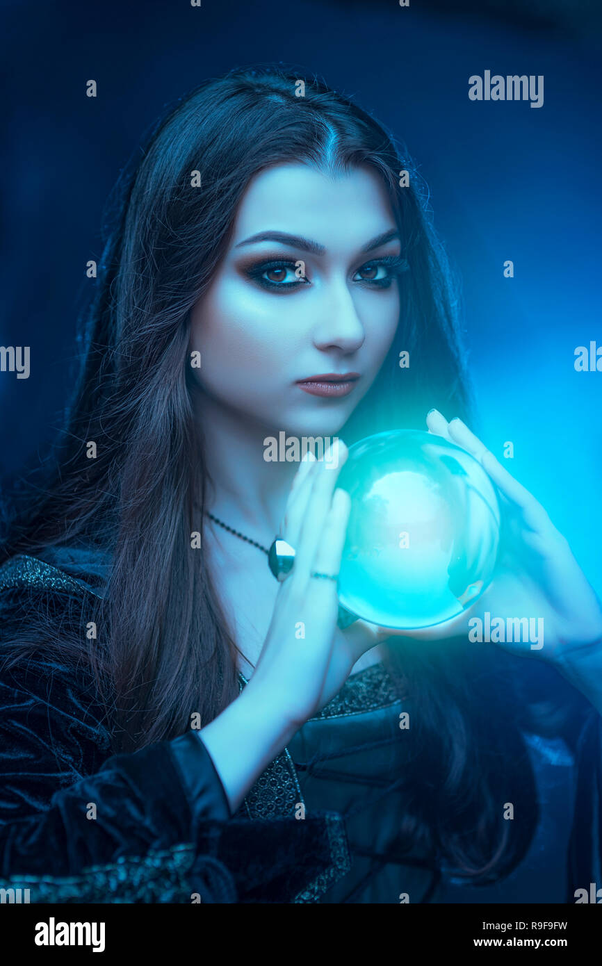 Die Hexe mit Magic Ball in den Händen verursacht eine Spirituosen Stockfoto