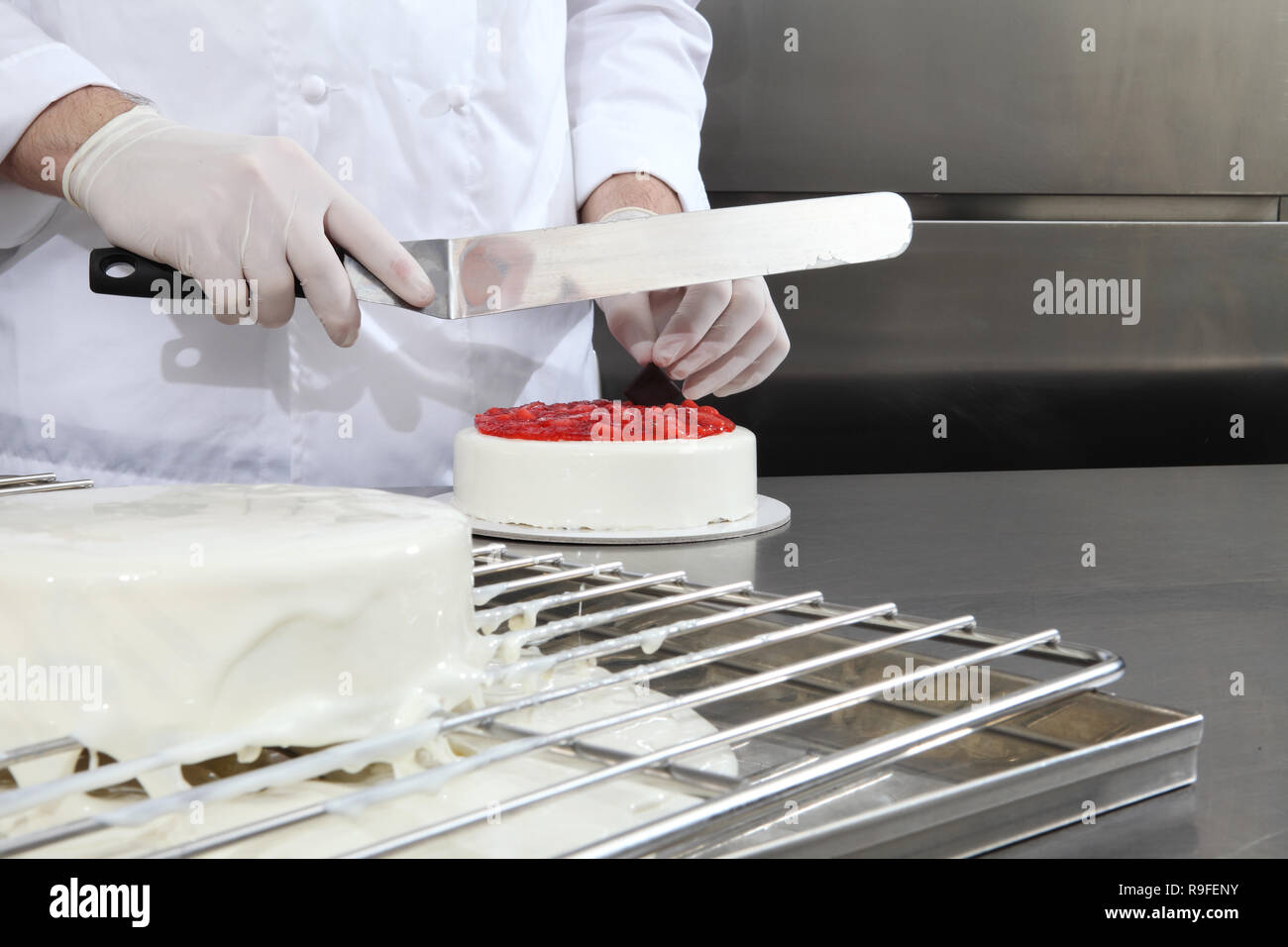Hände Konditor bereitet einen Kuchen, Deckel mit Puderzucker und mit  Erdbeeren verzieren, arbeitet an einem Edelstahl industrielle Küche  arbeiten Top Stockfotografie - Alamy