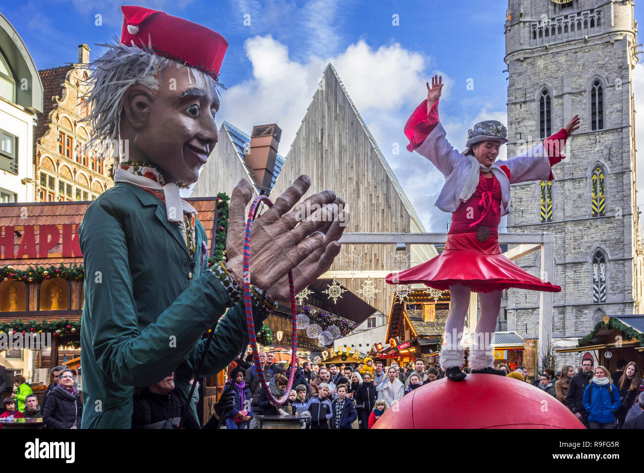 Puppenspielerin und Street Performer der Balanceakt auf riesige Kugel während der Weihnachtsmarkt im Winter in Gent, Flandern, Belgien Stockfoto