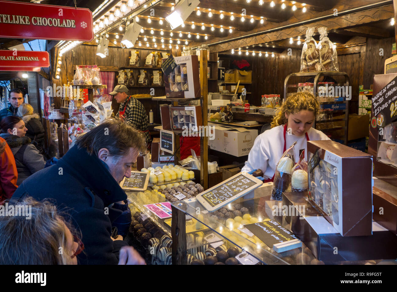 Straßenhändler, die Belgische Schokolade/Pralinen in der Weihnachtsmarkt im Winter in der Stadt Gent, Flandern, Belgien Abschaltdruck Stockfoto