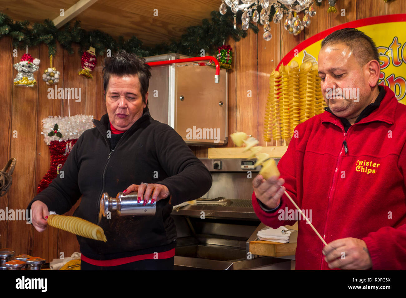Straßenhändler in Fastfood stand verkaufen twister Chips/Kartoffelchips auf Weihnachtsmarkt im Winter in der Stadt Gent, Flandern, Belgien verdreht Stockfoto