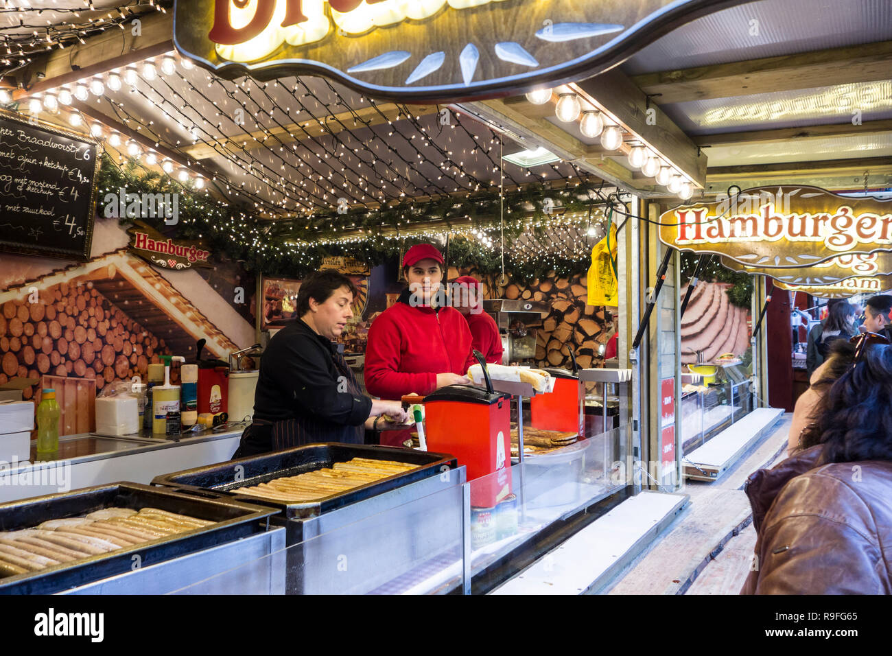 Straßenhändler in Fastfood stehen Verkauf von Hot Dogs am Weihnachtsmarkt im Winter in der Stadt Gent, Flandern, Belgien Stockfoto