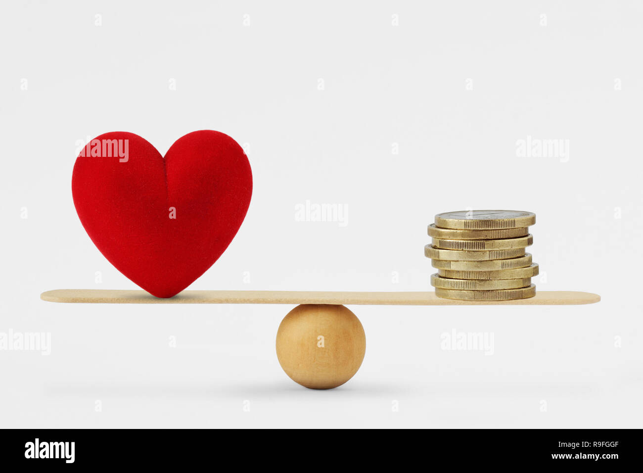 Herz und Geld auf Balance Scale-Reihenfolge der Priorität im Leben zwischen Liebe und Geld Stockfoto