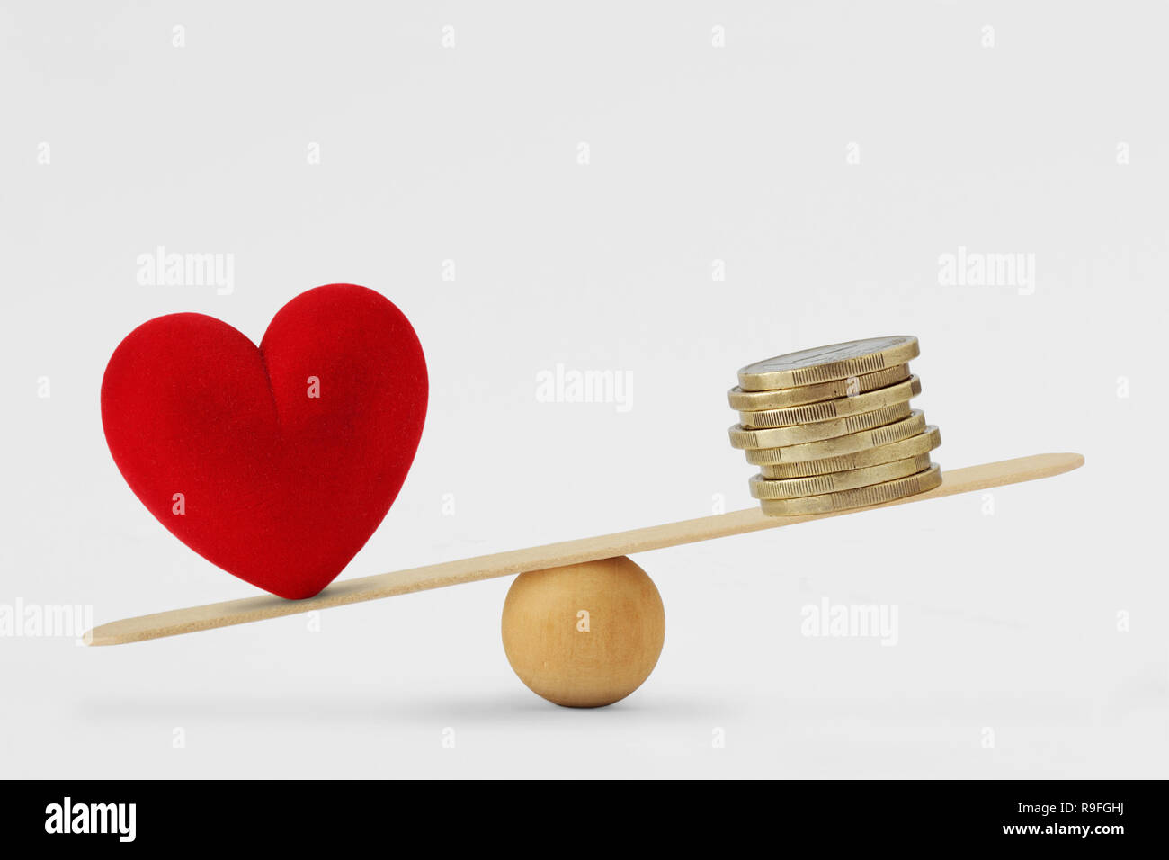Herz und Geld auf Balance Scale-Konzept der Liebe Priorität im Leben Stockfoto