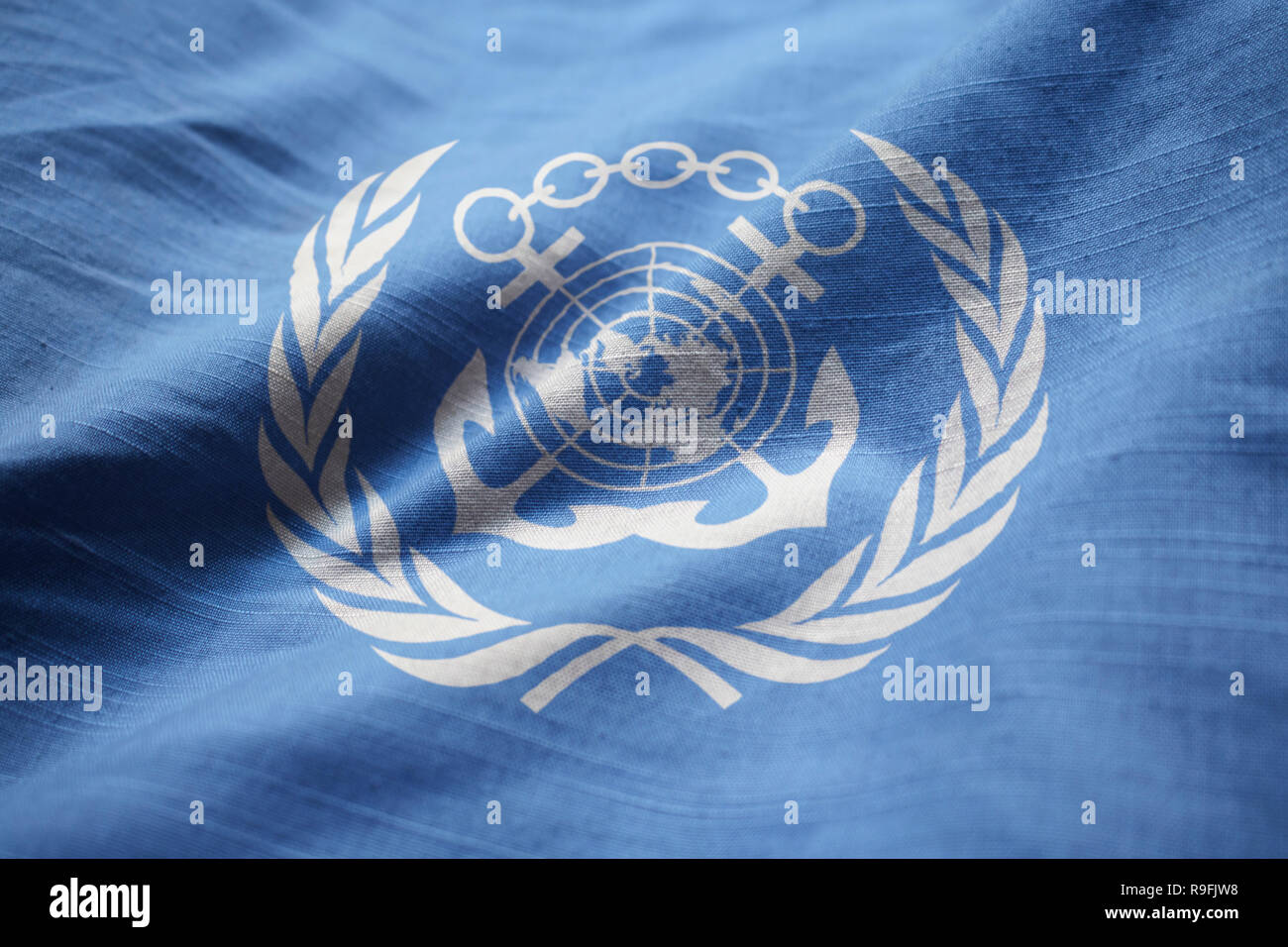 Nahaufnahme von gekräuselten International Maritime Organisation Flagge, der Internationalen Seeschifffahrtsorganisation Flagge weht im Wind Stockfoto