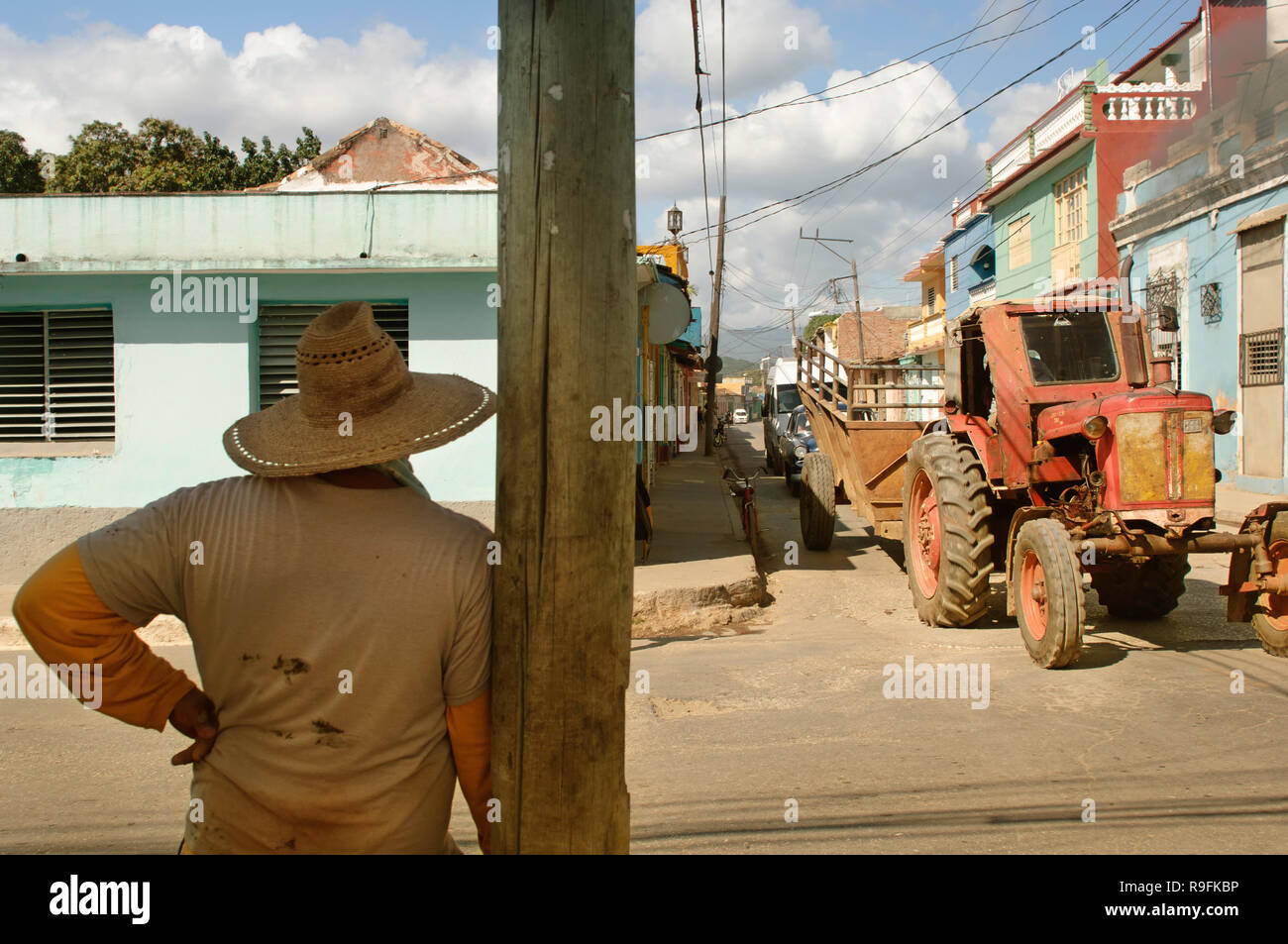 Ein Bauer mit einem Hut, einen alten Traktor vorbei auf den Straßen von Trinidad, Kuba. Stockfoto