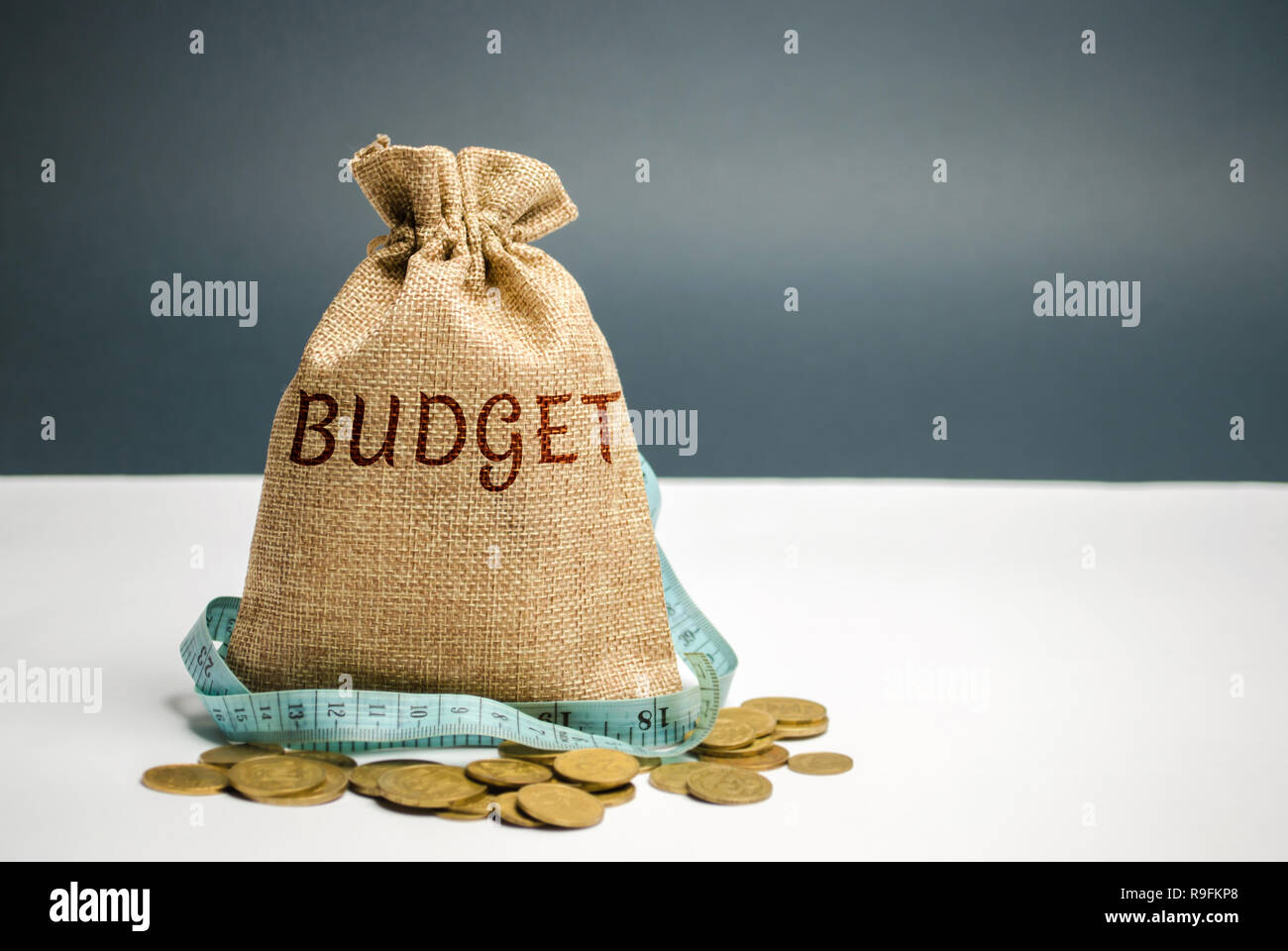 Beutel mit Geld und Maßband und das Wort Haushalt. Begrenztes Budget. Der Mangel an Geld. Das Konzept der Akkumulation von Geld in der Familie Haushalt. Familie ins Stockfoto