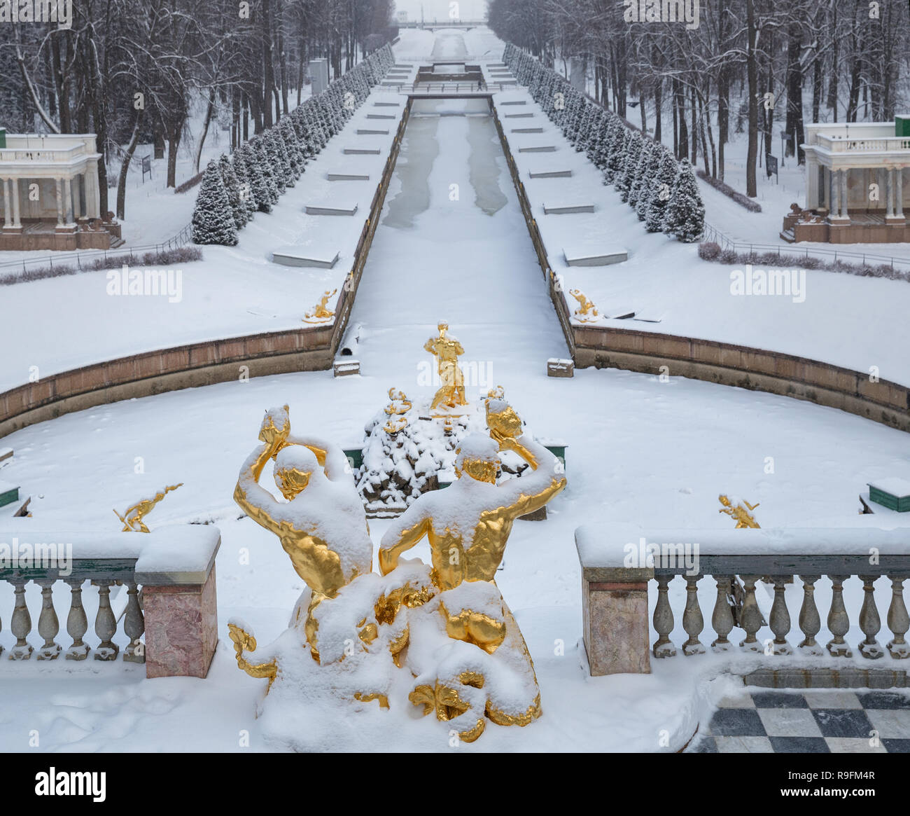 SAINT PETERSBURG, Russland - Januar 22, 2018: Peterhof im Winter. Statuen von Tritonen und Simson reißt das Maul des Löwen gegen das Meer Kanal. Stockfoto