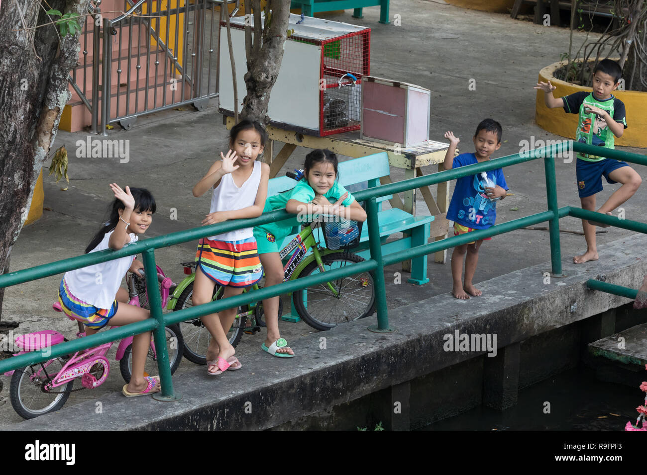 Thai Kinder beim Spielen an einem Kanal. Stockfoto