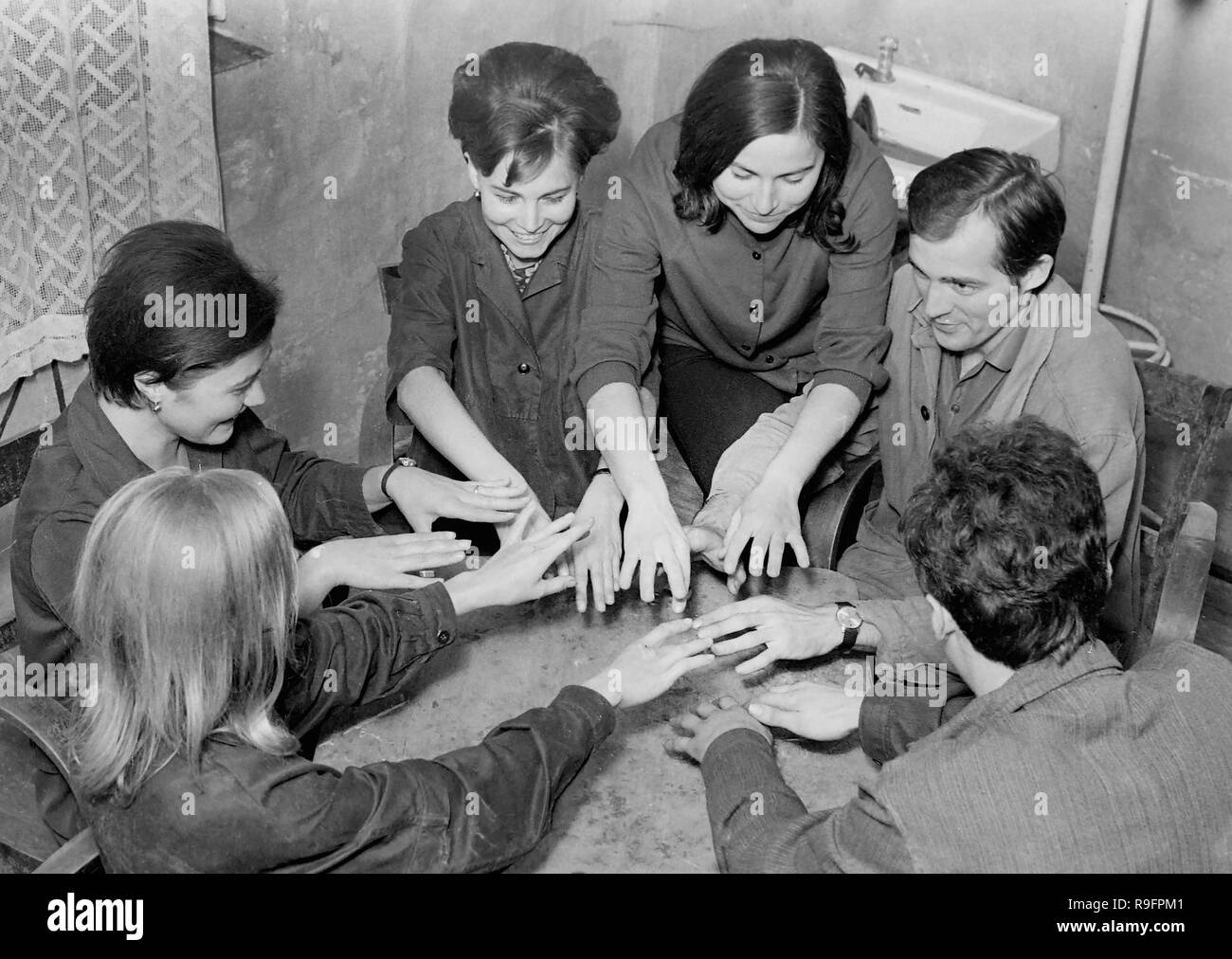 Eine Gruppe von jungen Erwachsenen, ein Gesellschaftsspiel zu spielen oder in einer Seance teilnehmen, Ca. 1955. Stockfoto