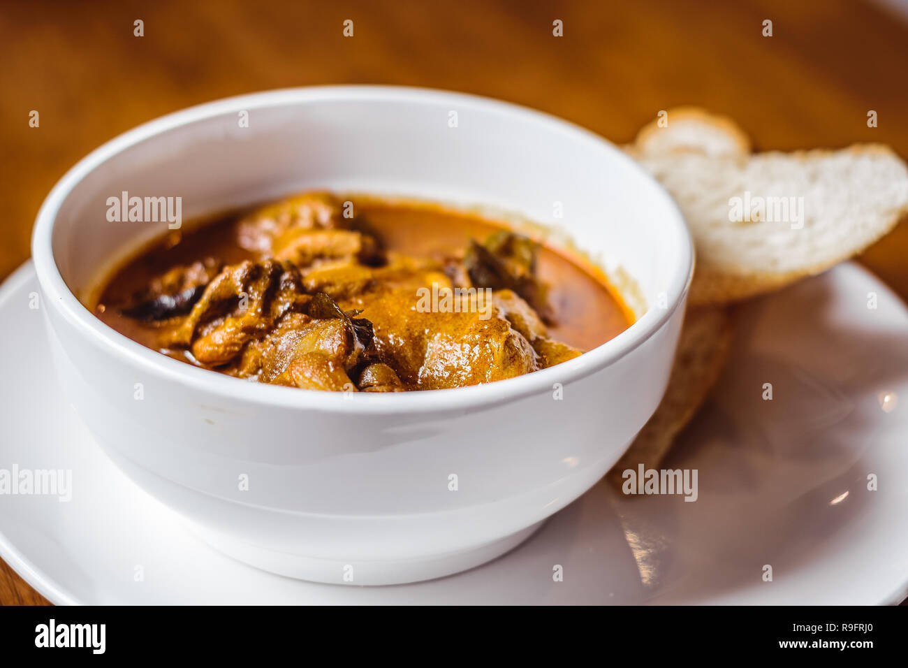 Hainanese Chicken Curry mit Baguette auf der Seite Stockfoto