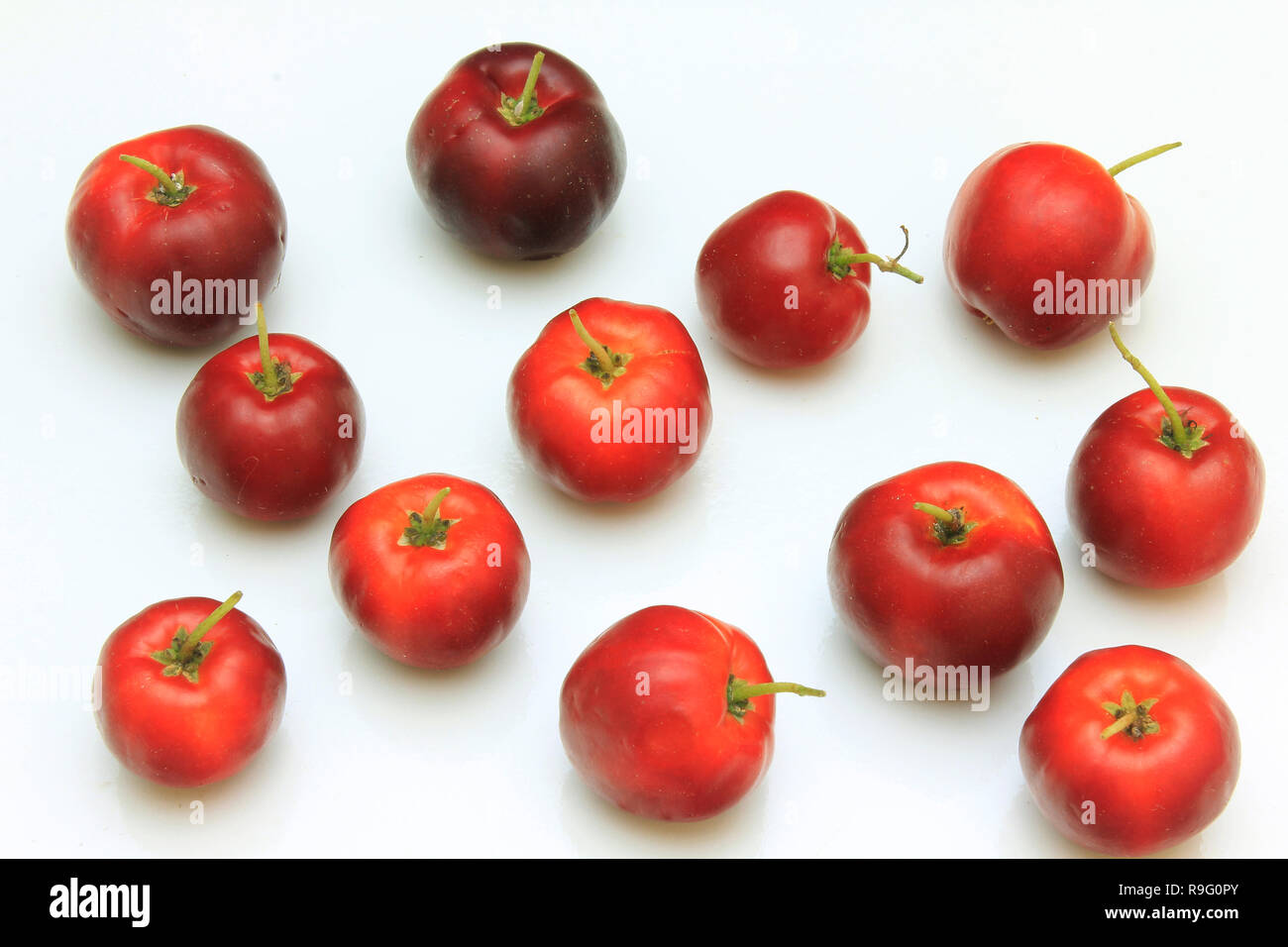 Makro Nahaufnahme von frischen Bio Acerola Gruppe, auf weißem Hintergrund mit Freistellungspfad isoliert. Antioxidative Früchte Stockfoto