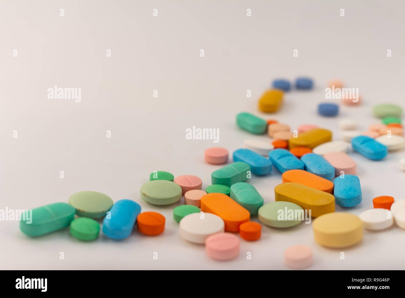Drogen in Form von Medikamenten. Kapseln und Tabletten in verschiedenen Farben und Formen für den menschlichen Gebrauch. Arzneimittel auf weißem Hintergrund. Stockfoto