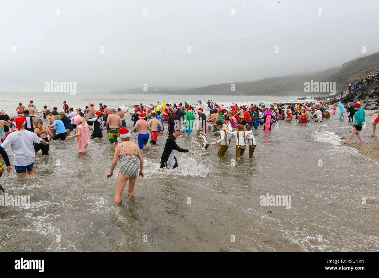 Charmouth, Dorset, Großbritannien. 25 Dez, 2018. Weihnachtstag Schwimmer tragen Fancy Dress Braving das kühle Wasser ein erfrischendes Bad im Meer bei Charmouth, Dorset zu nehmen Geld für die Rnli zu erhöhen. Foto: Graham Jagd-/Alamy leben Nachrichten Stockfoto