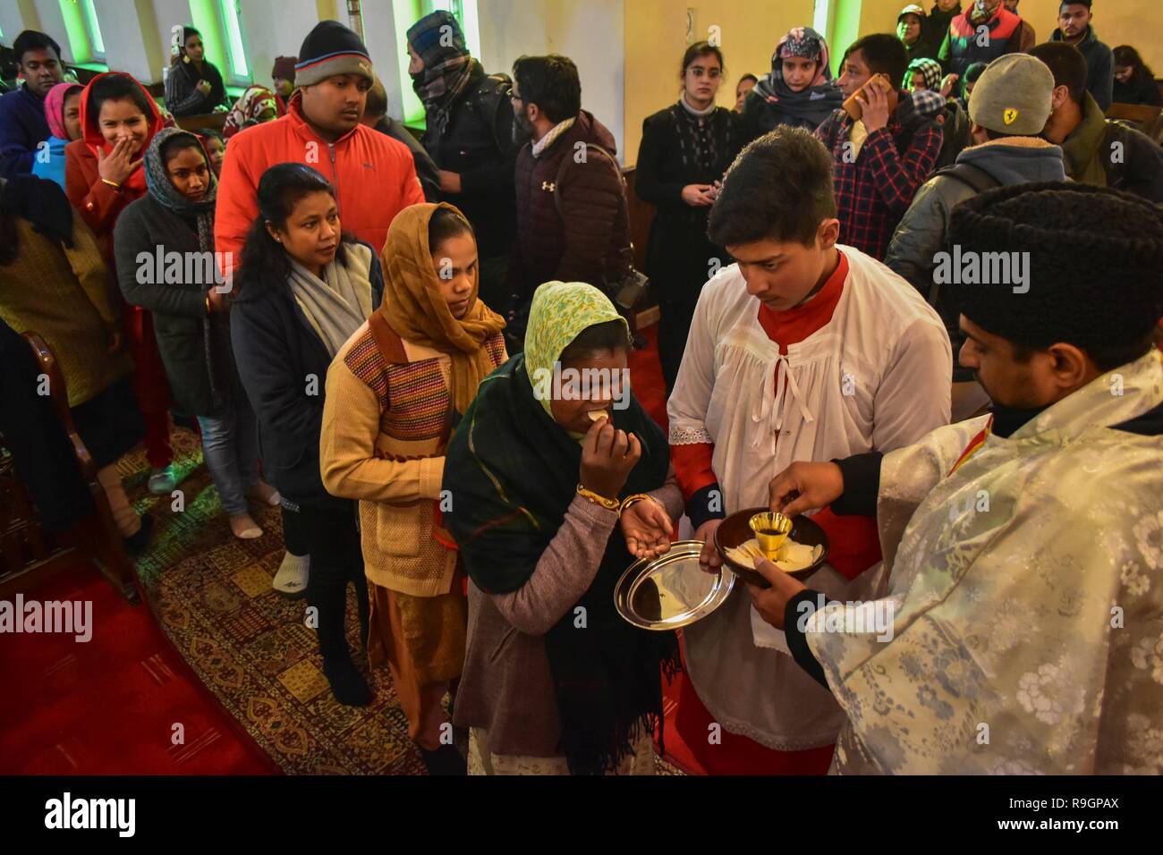 Srinagar, Indien. 25 Dez, 2018. Die christlichen Gläubigen empfangen die heilige Kommunion in der Heiligen Familie Katholische Kirche anlässlich des Weihnachten in Srinagar, Indien verwalteten Kaschmir. Inmitten einer beißende Kälte Wave in den Staat, die christliche Gemeinschaft des Tales am Dienstag feierte Weihnachten, den Geburtstag von Jesus Christus, mit Lebensfreude und Fröhlichkeit in Srinagar. Unter denen, die beteten, waren Touristen aus verschiedenen Teilen des Landes, die die Einheimischen auf die günstigen Tag verbunden und für den Frieden in Kaschmir und der Rest der Welt gebetet. Credit: SOPA Images Limited/Alamy leben Nachrichten Stockfoto