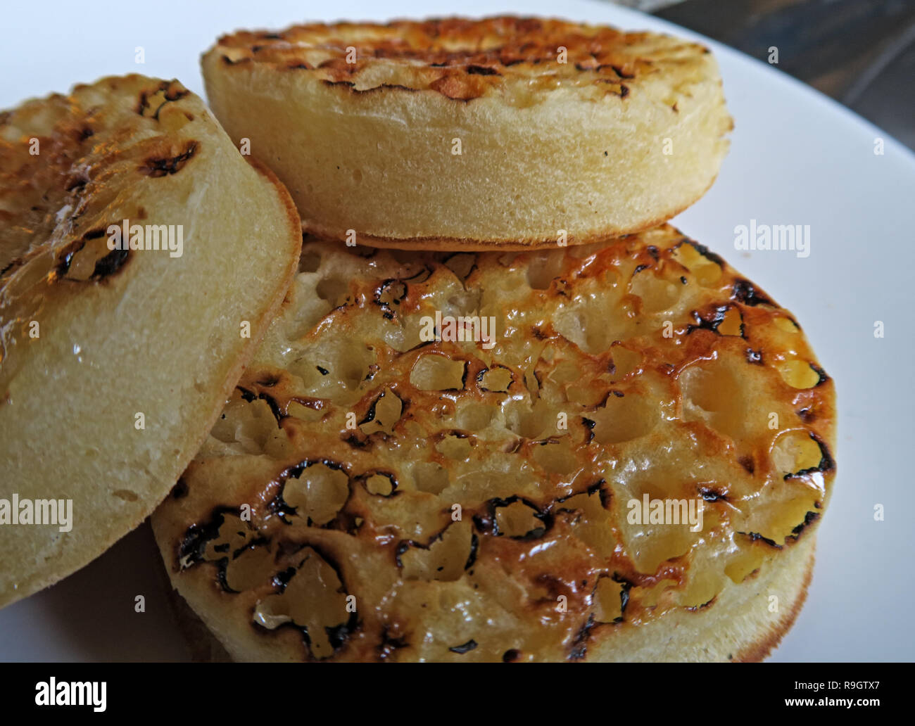 Drei getoastet mit Butter bestrichenen Englischer Teekuchen auf einer weißen Platte Stockfoto