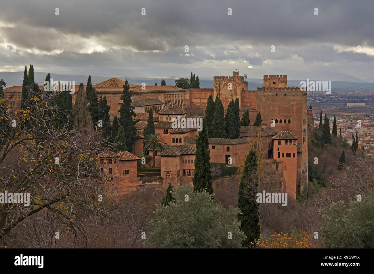 Alhambra mittelalterliche maurische Burg auf einem Hügel, mit Zypressen und die Stadt Granada unten an einem bewölkten Tag Stockfoto