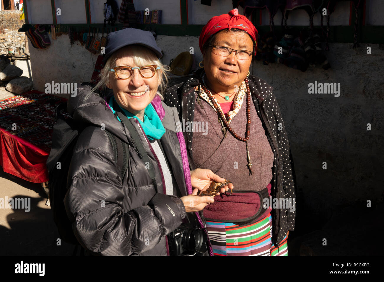 Np 950 Nepal, Everest Base Camp Trek, Khumjung Dorf, Trekker mit lokalen Frau an einer kleinen touristischen Souvenirs auf der Straße abgewürgt zu Dorf Gompa Stockfoto