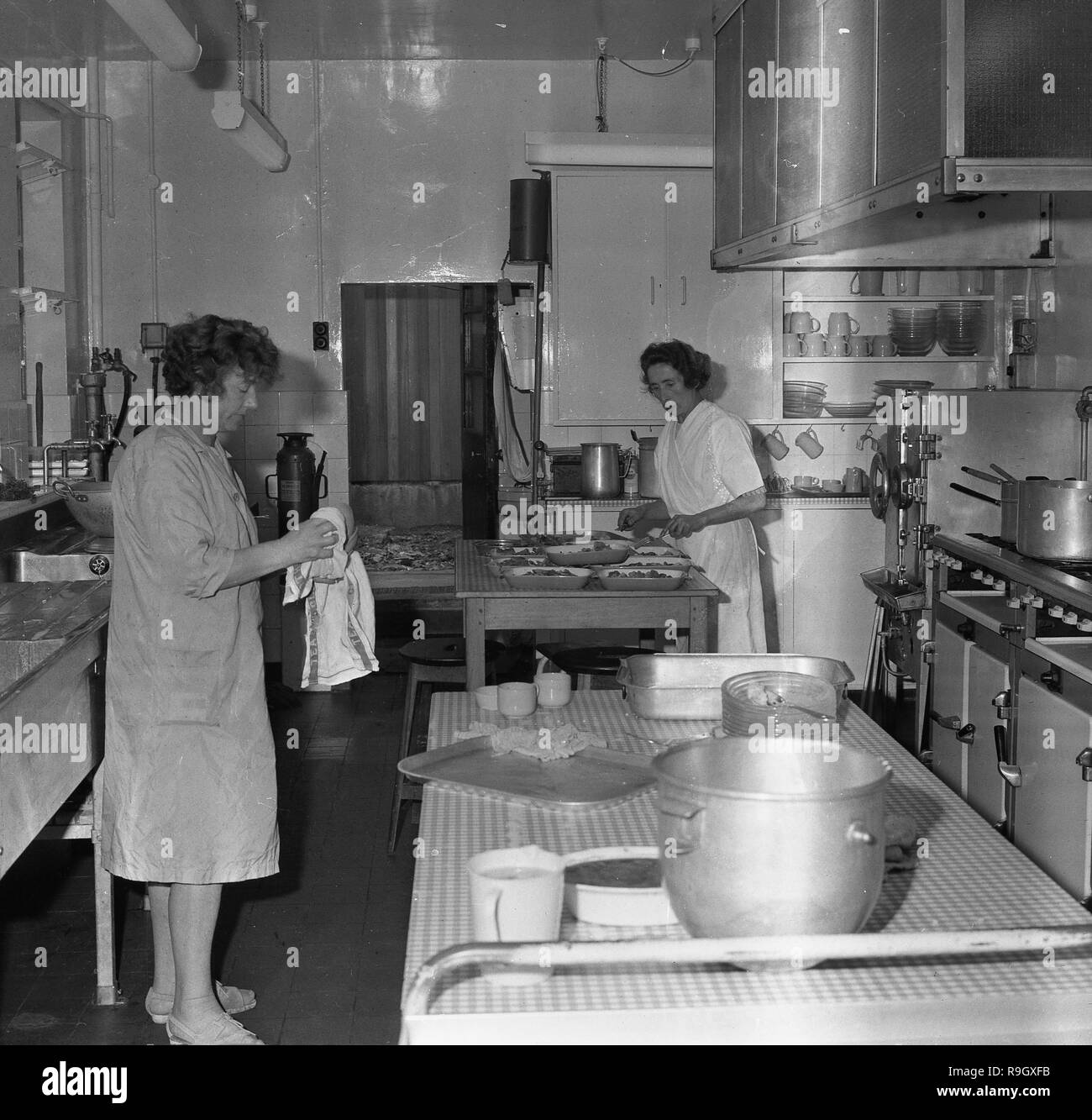 1968, South London, innerstädtischen jungen Boarding School, England, zwei Köchinnen in der Schule Küche, England, UK. Stockfoto