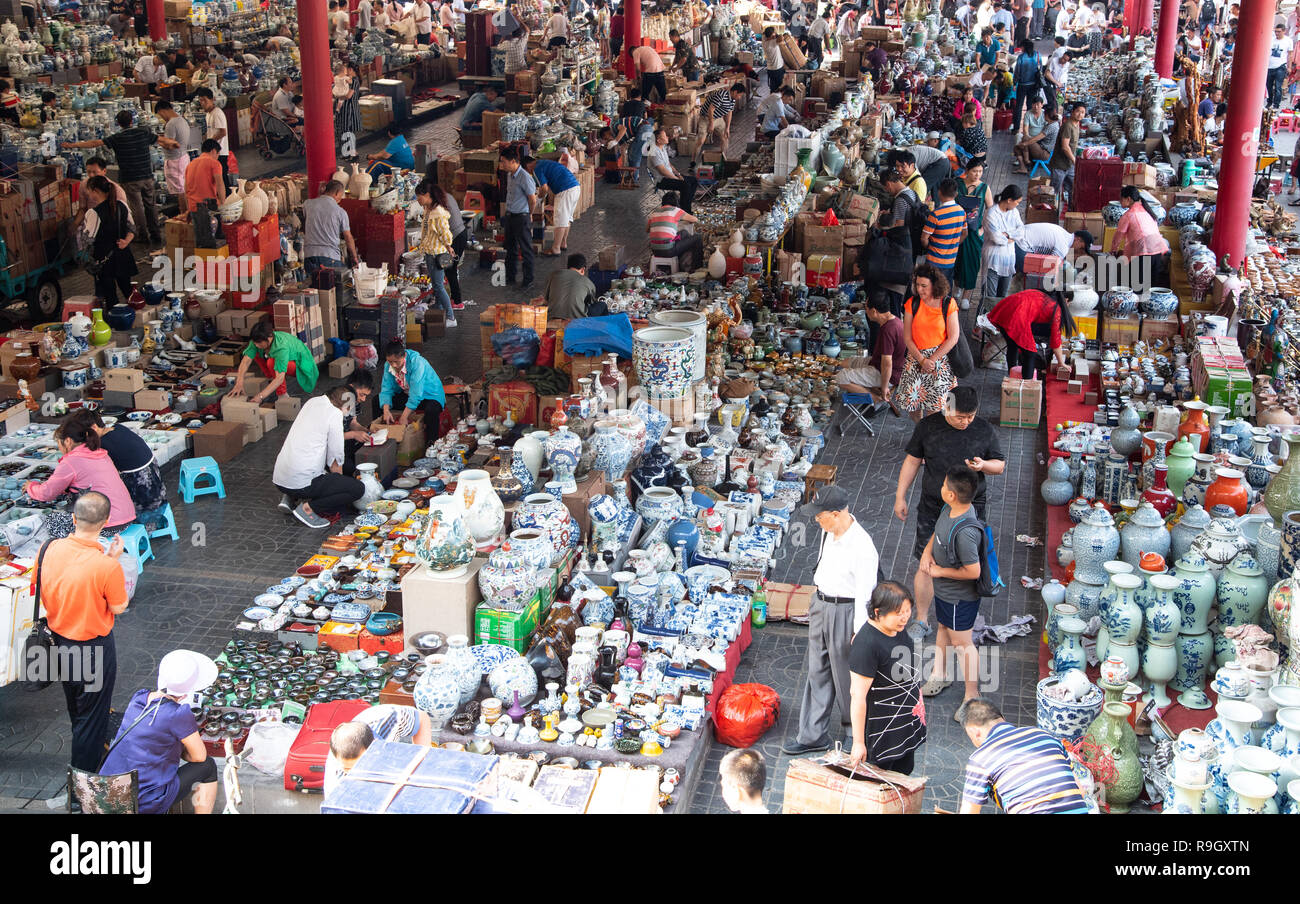 Händler und Käufer verkaufen ihre Waren auf dem Flohmarkt Panjiayuan Antique Market in Peking, China. Stockfoto