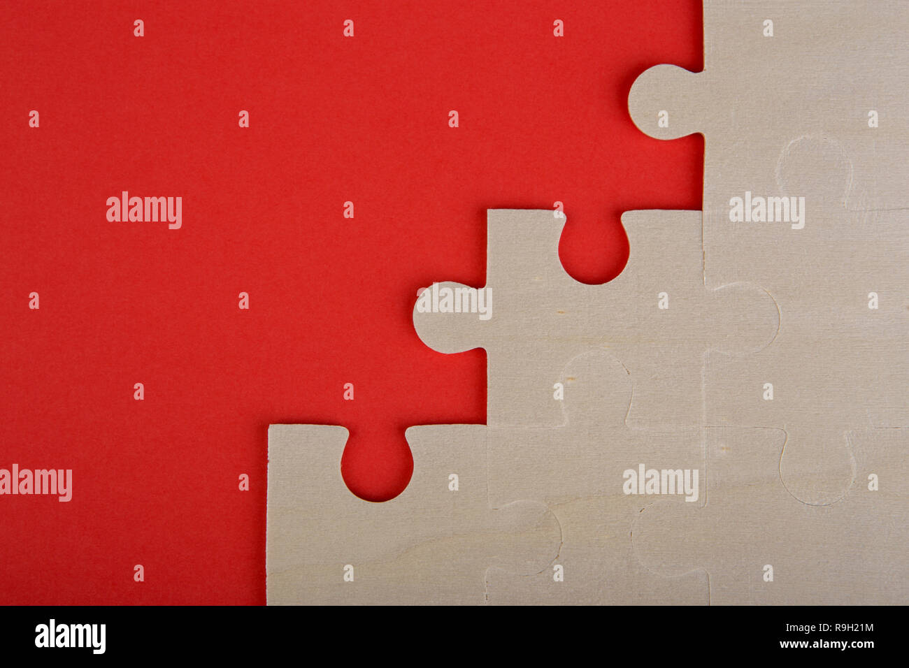 Holzpuzzle Stücke auf einem roten Hintergrund Stockfoto