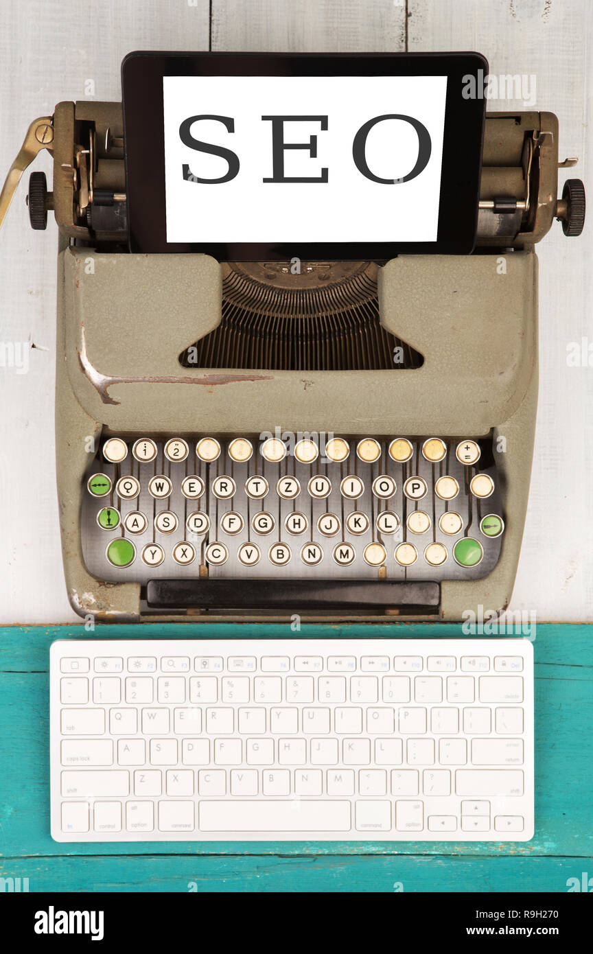 Alte Schreibmaschine, neuer Computer Tastatur und Tablet PC mit der text EO' auf Holz- Hintergrund Stockfoto