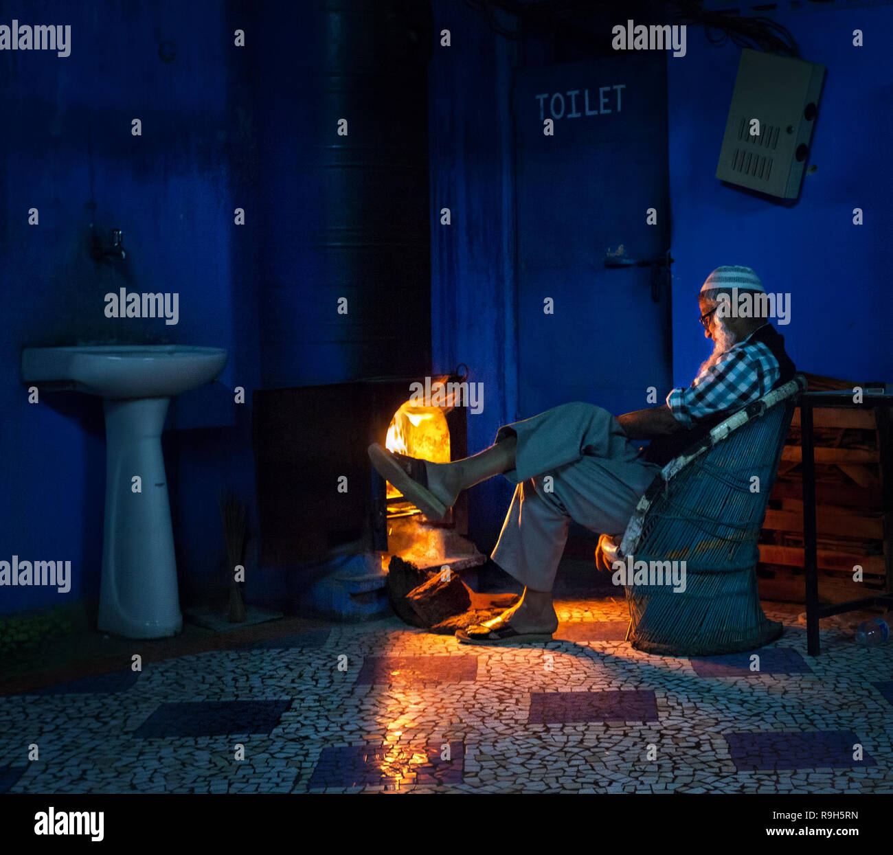 JODHPUR, Rajasthan, Indien - 8. MÄRZ 2015: alte moslemische Mann in der Nähe der Feuer sitzen am Abend im Blue City Hotel Stockfoto