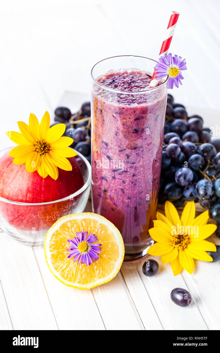 Aus Trauben-, Apfel- und Zitronensaft auf weißem Hintergrund Smoothie aus Holz Stockfoto