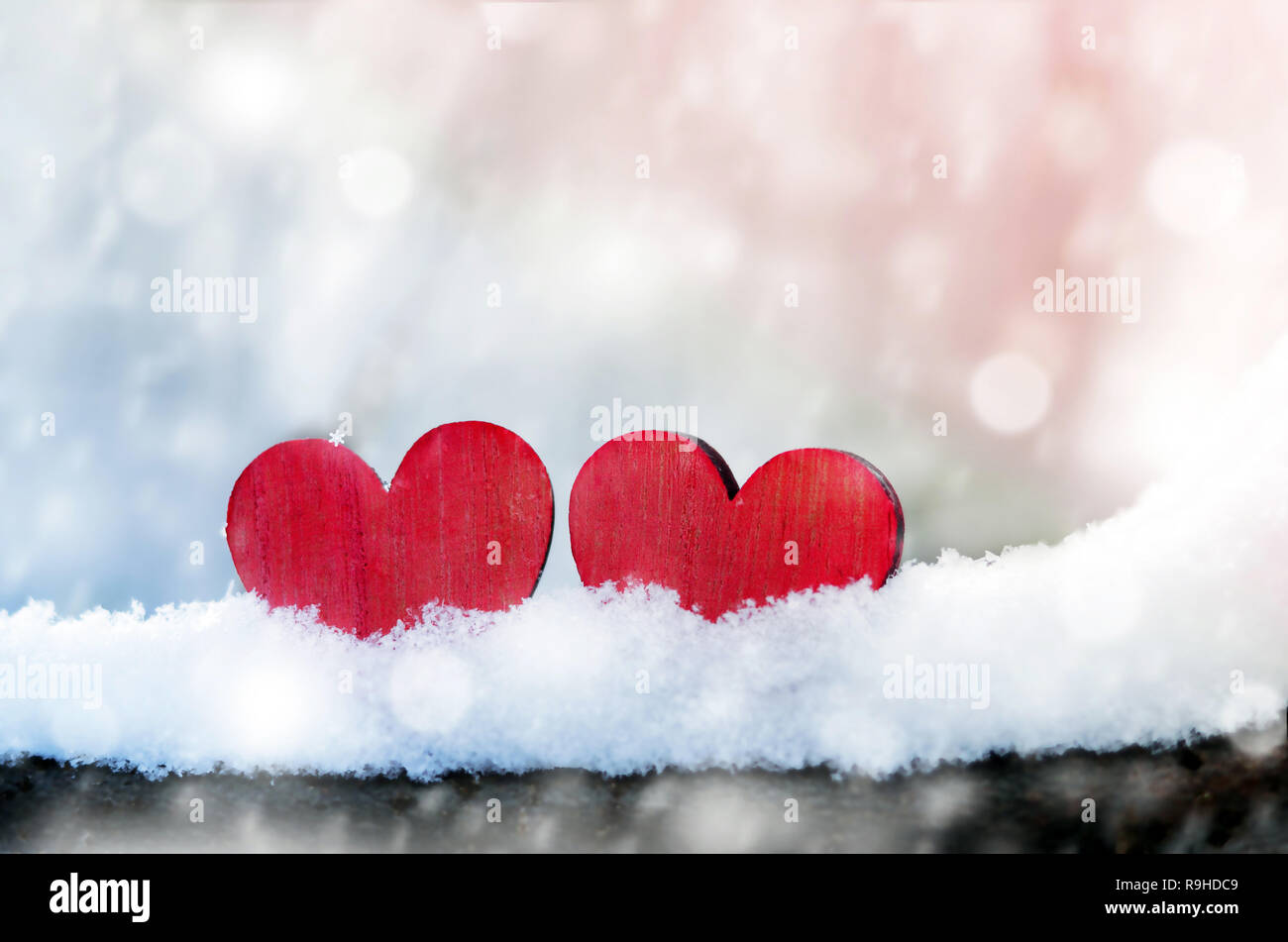 Zwei schöne romantische Vintage rote Herzen zusammen auf einem weißen Schnee Winter Hintergrund. Liebe und St. Valentines Tag Konzept Stockfoto