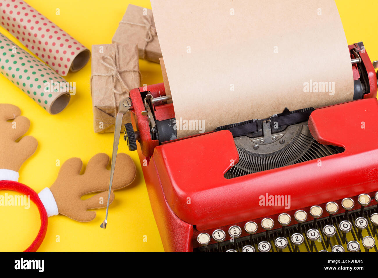 Urlaub Konzept - rot Schreibmaschine mit leeren Handwerk Papier, Geschenk, Kästen und Verpackung Papier auf gelbem Hintergrund Stockfoto