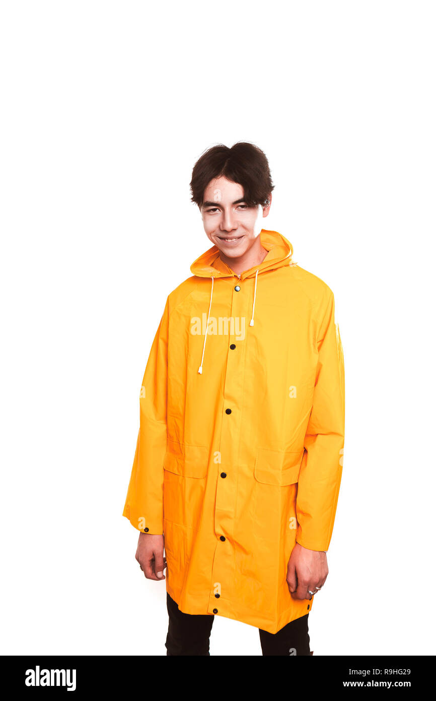 Porträt einer jugendlich Kerl in einem gelben Regenmantel brunette im Studio. Stockfoto