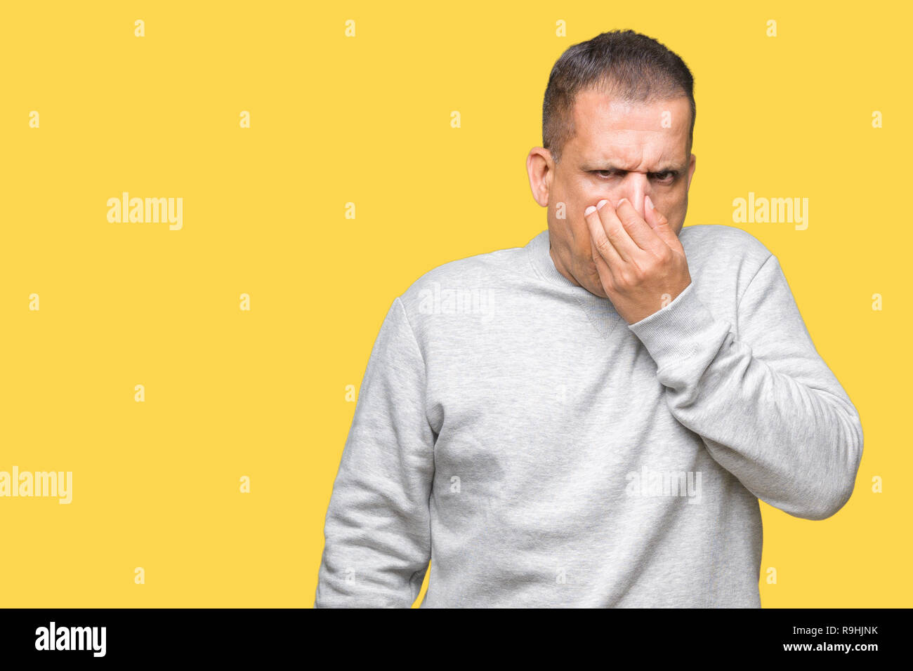 Mittleres Alter arabischer Mann tragen Sport Sweatshirt über isolierte Hintergrund riechen etwas stinkig und ekelhaft, unerträglichen Geruch, mit Atem Stockfoto