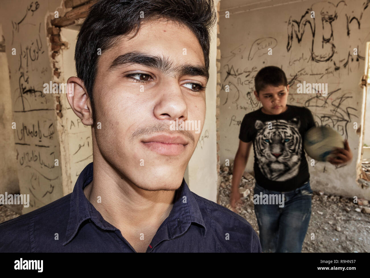 Teenager Jungs Fußball spielen innerhalb des zerstörten Haus Stockfoto