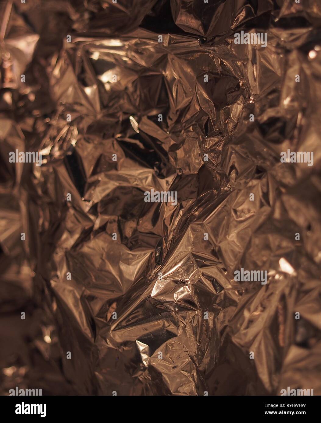 Eine Oberfläche mit vielen Gesichtern. Silber metallic Glanz. Zerknitterte Folie. Zusammenfassung Hintergrund Fotografie Stockfoto