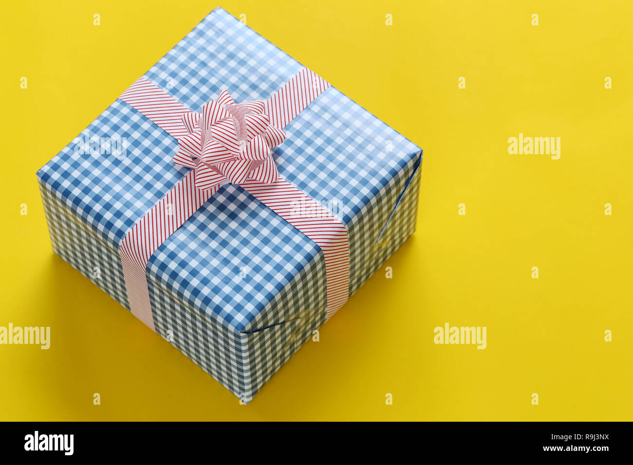 Blue Christmas Gift box auf gelbem Papier Boden gelegt und haben kopieren Sie Raum für Design in ihre Arbeit wichtiger Tag Konzept. Stockfoto