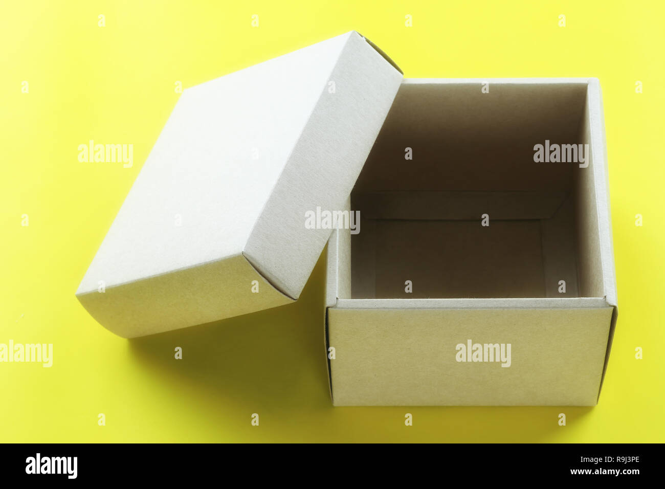 Leeren braunen Karton ruht auf gelbem Papier, und haben Sie Raum für Design in Ihrem Weihnachten arbeiten Konzept. Stockfoto