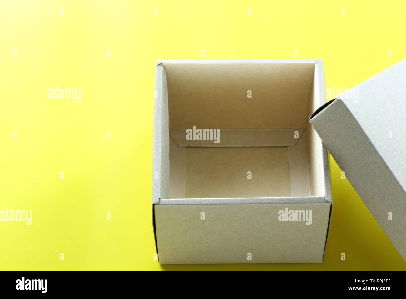 Leeren braunen Karton ruht auf gelbem Papier, und haben Sie Raum für Design in Ihrem Weihnachten arbeiten Konzept. Stockfoto