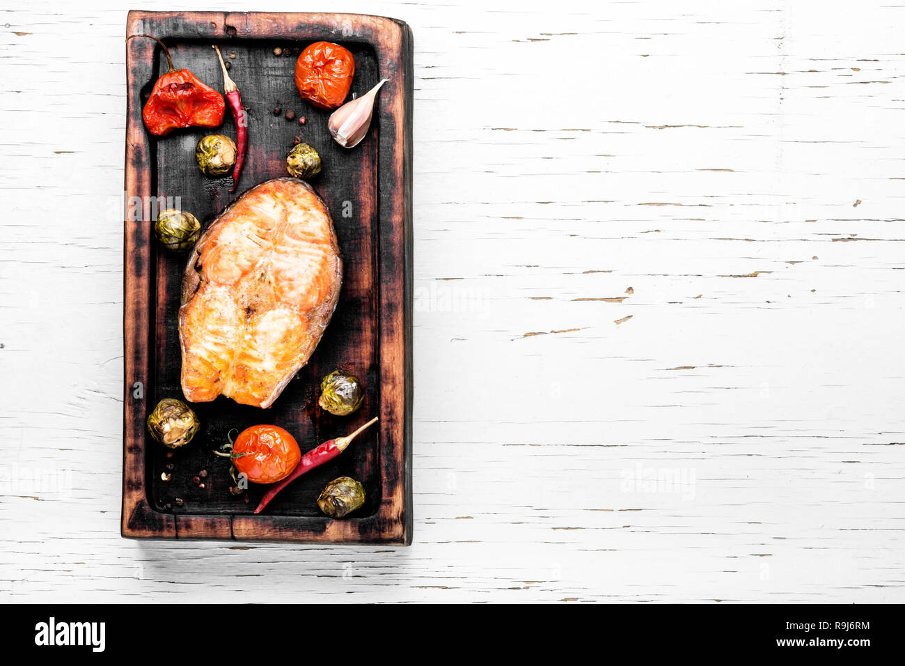 Lachs braten Steak auf Holz- retro Hintergrund. Fisch Steak mit Gemüse garnieren. Stockfoto