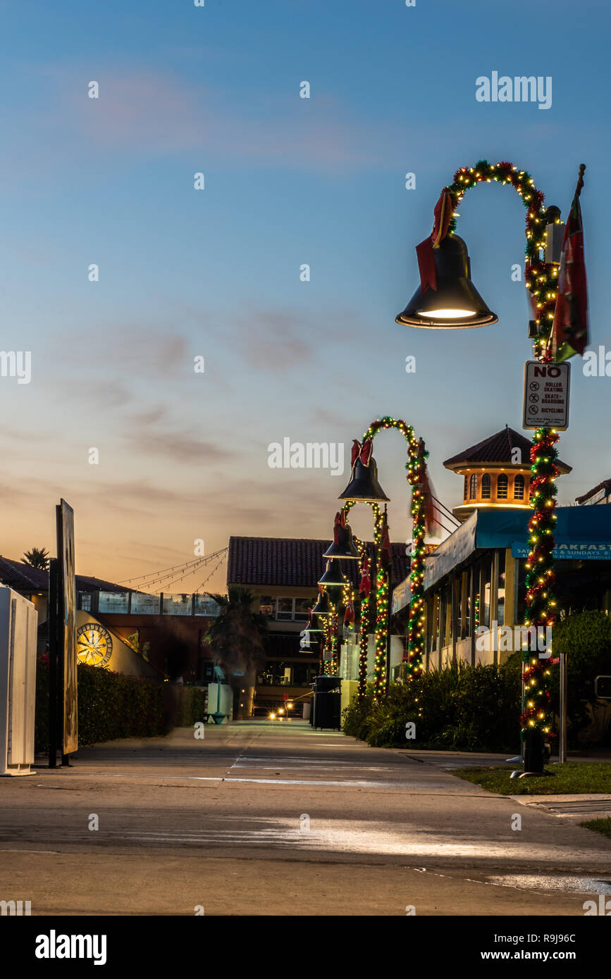 Weihnachtsbeleuchtung aufgewickelt um die Lampen vor Landmark Tower entlang Ventura Harbour Shops in Kalifornien, USA, am 24. Dezember 2018. Stockfoto